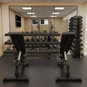 Dumbbell racks and weight benches in the mirrored free-weights area at The Southwold Gym